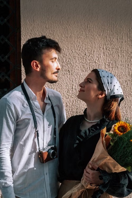 Claire and Adrien looking at each other, Adrien with a camera around his neck